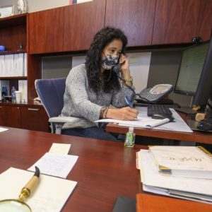 Staff in mask on phone for covid questions